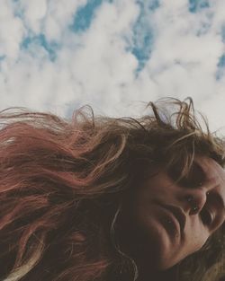 Close-up of young woman against sky