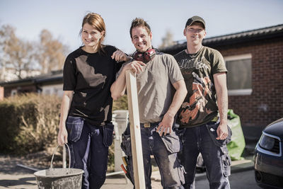 Portrait of confident carpenters standing at construction site