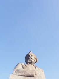 Low angle view of statue against clear blue sky