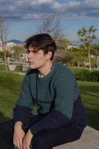 Portrait of a young man wearing a crocheted sweater 