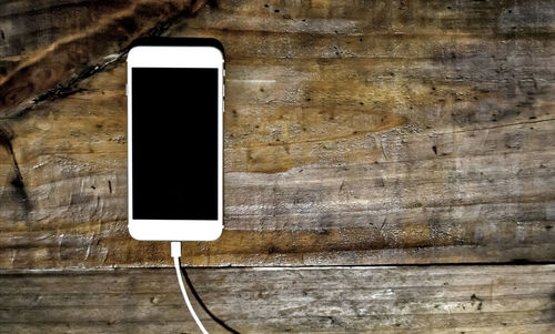 Directly above shot of mobile phone charging on table