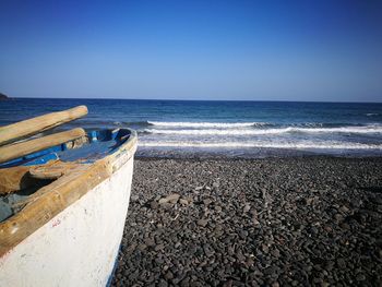 Scenic view of beach against clear blue sky