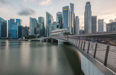 Bridge over river in city against sky