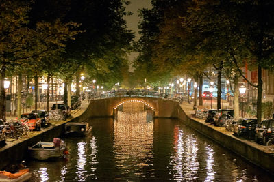 Illuminated bridge over water at night