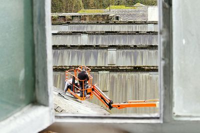 Men fixing roof tiles