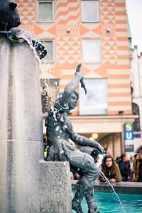 Statue of fountain against buildings in city