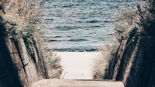 View of narrow alley along calm sea