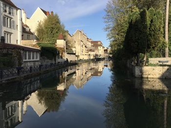 Buildings by lake against sky