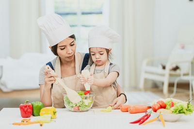 Midsection of woman having food in kitchen