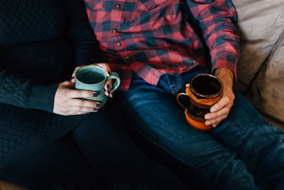 Midsection of couple holding camera