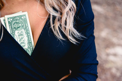 Close-up of money in cleavage of woman 