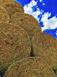 Hay bales on field against sky