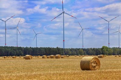 Hay bales on field against sky