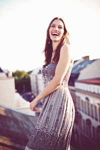 Happy woman laughing on rooftop 