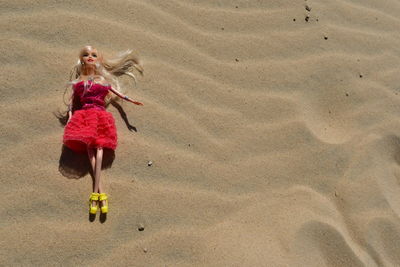 Woman with umbrella on sand