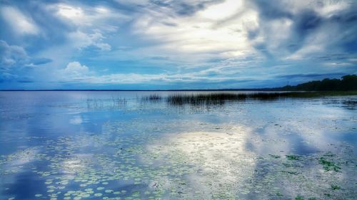 Scenic view of lake against cloudy sky