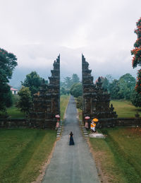 Rear view of woman standing on road