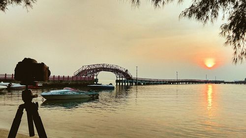 Bridge over river against sky during sunset