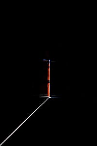 Close-up of illuminated lamp over black background