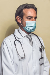 Doctor wearing mask against colored background