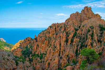 Scenic view of mountain by sea against sky