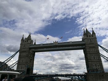 Low angle view of bridge against cloudy sky