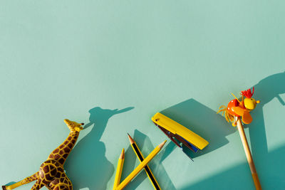 High angle view of toys and pencils on blue background
