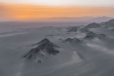 Scenic view of snowcapped mountains against sky during sunset