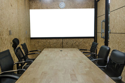 Empty chairs and conference table in board room