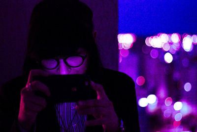 Portrait of man using smart phone at night