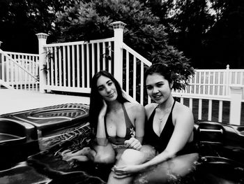 Portrait of smiling friends sitting in hot tub