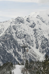 Cable car hanging against snowcapped mountains