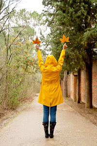 Full length of young woman standing against trees