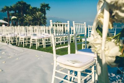 Chairs by swimming pool on beach against clear sky