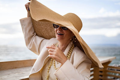 Woman wearing hat against sea