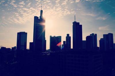 Skyscrapers in city against sky during sunset