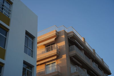 Low angle view of buildings against clear blue sky