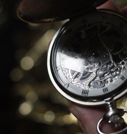 Cropped hand holding pocket watch