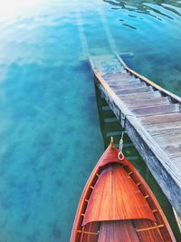 Boat moored by steps on lake