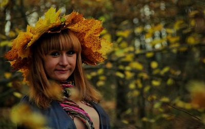 Portrait of smiling young woman standing against plants