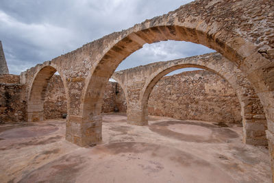 Old ruins of building against cloudy sky