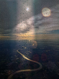 Aerial view of city seen through wet window