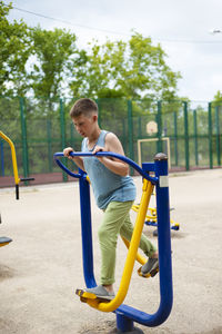 Outdoor exercise on simulators.  a teenager stands on a simulator platform.  positive emotions 