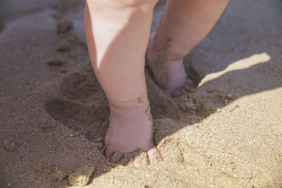 Feet of a baby who walks along the seashore