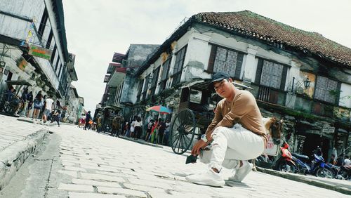 Man walking on street amidst buildings in city