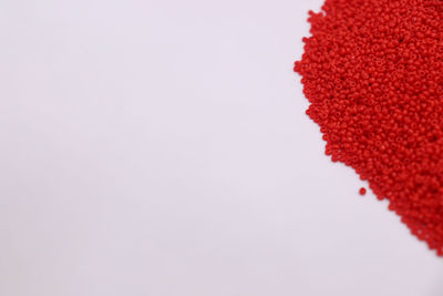 High angle view of red berries over white background