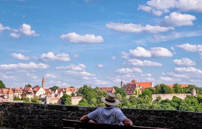 Rear view of man sitting on a bench 