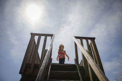 Girl standing on lookout tower against sky