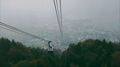 Overhead cable car over mountains against sky