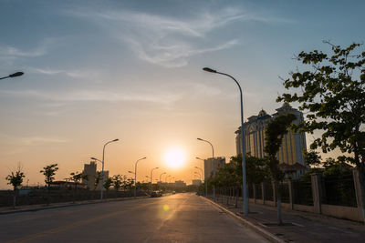 Road against sky during sunset in city